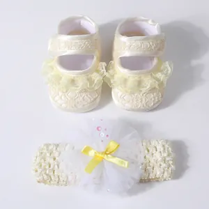 Detailed view of cream lace baby shoes with ruffled trim and matching floral headband set