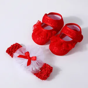 Detailed view of red lace baby walking shoes and matching bow headband set.