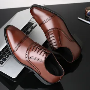 Primer plano de zapatos Oxford marrones con elegantes detalles brogue y fondo de laptop