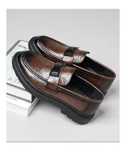 Vista detallada de mocasines de cuero marrón para hombre con suela gruesa y hebilla