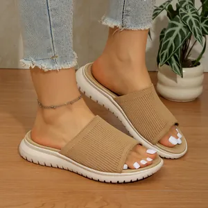 Primer plano de sandalias de cuña de punto caqui con suela de plataforma blanca