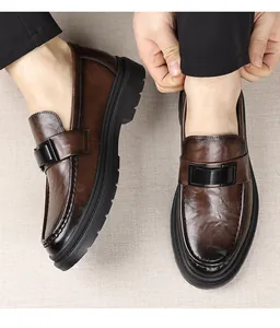 Primer plano de mocasines de cuero marrón con suelas gruesas y hebilla metálica