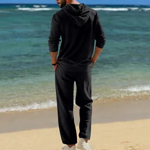 Rückansicht eines locker sitzenden schwarzen Leinen-Kapuzen-Sets für Herren am Strand