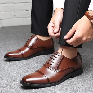 Primer plano de elegantes zapatos Oxford de cuero marrón mientras se atan los cordones.