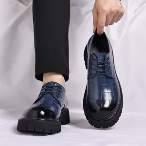 Primo piano di scarpe blu da uomo con motivo a coccodrillo e suola spessa.