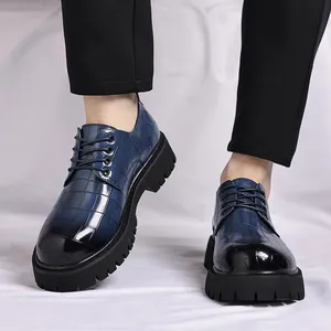 Primo piano di scarpe platform in pelle blu goffrata coccodrillo con pantaloni neri