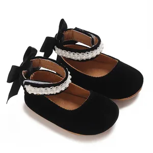 Detailed view of baby girl black velvet Mary Jane shoes with elegant pearls and bows