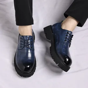 Primo piano di scarpe da uomo in pelle blu motivo coccodrillo con suola spessa nera