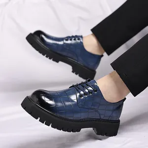 Scarpe da uomo blu con motivo a coccodrillo e suola spessa indossate da un modello