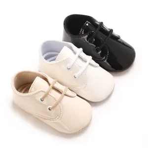 Scarpe primi passi neonato in pelle verniciata lucida, colori nero, bianco e beige.