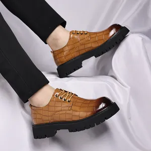 Dettaglio di scarpe da uomo in pelle marrone motivo coccodrillo con spessa suola nera