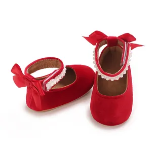 Close-up detail of red velvet baby girl shoes featuring pearl straps and satin bows