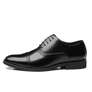 Zapatos Oxford clásicos de cuero negro para hombre con detalles brogue y cordones.