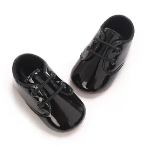 Dettaglio ravvicinato di scarpe da bambino in vernice nera lucida con stringhe