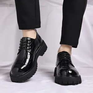 Primo piano di scarpe da uomo in pelle nera a coccodrillo con suola spessa