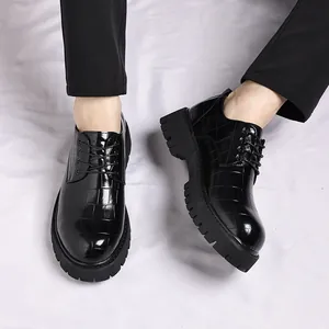 Dettaglio di scarpe stringate da uomo in pelle nera con texture a coccodrillo
