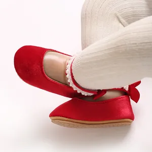 Close-up of red velvet baby girl princess shoes with pearl trim and bow