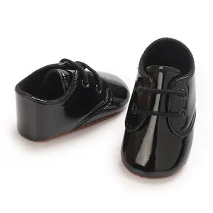 Dettaglio delle scarpe da bambino in nero lucido con lacci e suola antiscivolo morbida