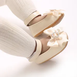 Detailansicht beige Baby Mary Jane Schuhe mit Seidenschleife und Kristall-Schnalle.