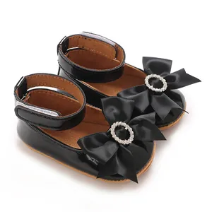 Elegante schwarze Lacklederschuhe für Babys mit großer Schleife und einem Strassring.