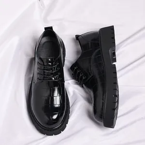 Dettaglio ravvicinato delle scarpe platform nere da uomo in pelle con motivo a coccodrillo