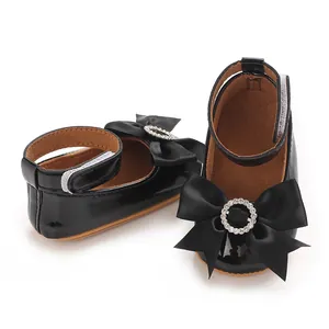 Detailansicht schwarzer Lackleder-Prinzessinenschuhe mit dekorativer Schleife.