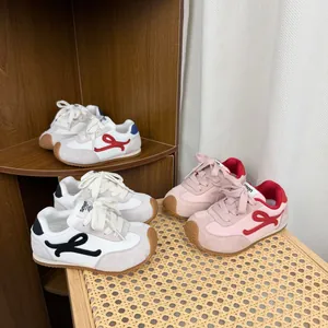 Collection of children's German trainers in pink, black, and red colorways on display.