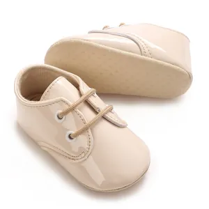 Dettaglio scarpine neonato in vernice beige con suola in tessuto antiscivolo