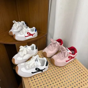 Multiple colors of children's German trainers displayed on wooden and rattan furniture.