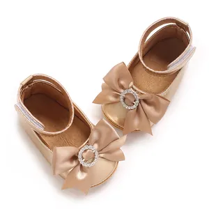 Detailansicht von champagnerfarbenen Baby-Prinzessin-Schuhen mit großer Satinschleife.
