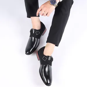 Detail of men's black monk strap business shoes with mixed leather textures and pointed toe.