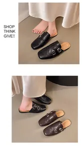 Λεπτομερής άποψη των ρετρό brogue mules με αγκράφες ζώνης και σκαλιστά σχέδια.