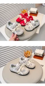 Detailopname van grijs-rode Duitse legertrainer-sneakers voor meisjes voorjaar