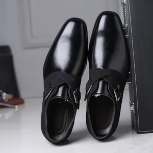 Detail view of formal black men's dress shoes with leather and suede cross-straps.