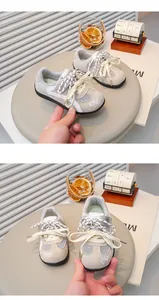 Boven- en vooraanzicht van grijze mesh sneakers voor kinderen met strikborduursel.