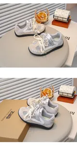 Close-up van ademende kinder sneakers van mesh met elegant borduurwerk van een strik.
