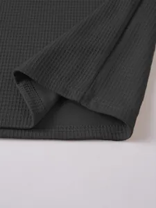 Close-up of charcoal grey waffle knit texture and hem stitching on men's Henley shirt.