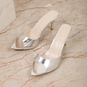 Elegant silver peep-toe high-heeled mule sandals displayed on a polished marble surface