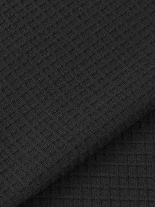 Macro detail of black waffle knit fabric texture for men's casual summer Henley shirt