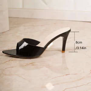 Detail of 8cm stiletto high heel on black patent leather peep toe mule sandal