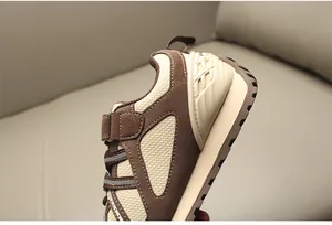Primer plano detallado de zapatillas infantiles de malla transpirable marrón y beige