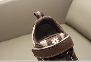 Detalle de zapatillas de malla marrón para niños con cierre de velcro y cuello acolchado