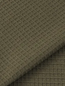 Macro view of olive green waffle knit fabric texture for men's casual Henley t-shirt