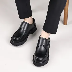 Chaussures en cuir noir pour homme avec semelle épaisse crantée et boucle élégante.