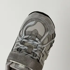 Primer plano de zapatillas infantiles de malla transpirable con gamuza gris y tira.