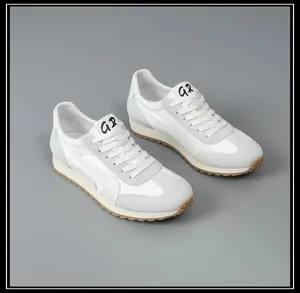 Vue de côté de baskets décontractées en cuir et tissu blanc et gris à semelle