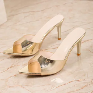Detailed view of elegant gold metallic high-heeled mule sandals with pointed open toe design