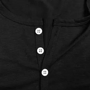 Close-up detail of black Henley shirt neckline with three white buttons and slub texture