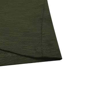 Close-up macro view of olive green slub cotton T-shirt hem featuring durable double stitching.