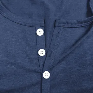 Macro shot of navy blue slub cotton fabric texture and three white buttons on a shirt